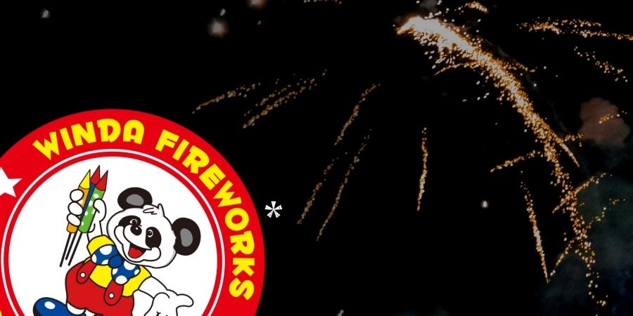 Winda Fireworks logo with a panda clown holding fireworks. Click to shop Winda Fireworks products available at Elite Fireworks. Explosive fireworks backdrop in red, yellow, and blue colors.
